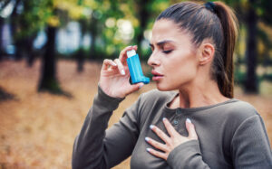 Woman with ponytail using an inhaler